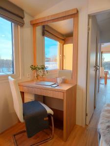 Zimmer mit einem Schreibtisch mit einem Spiegel und einem Stuhl in der Unterkunft Masuria Resort Village, całoroczne domki z widokiem na jezioro, sauna i jacuzzi in Żywki