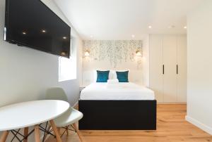 ein Schlafzimmer mit einem großen Bett mit blauen Kissen in der Unterkunft Sale Place Serviced Apartments by Concept Apartments in London