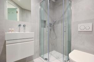 ein Bad mit einer Dusche, einem WC und einem Waschbecken in der Unterkunft Sale Place Serviced Apartments by Concept Apartments in London