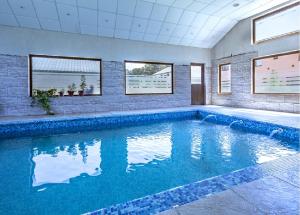 a swimming pool with blue water in a house at Hosteria Quiñe in Caviahue