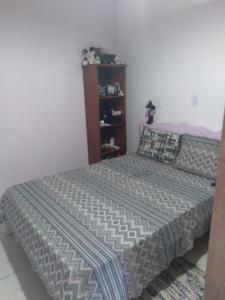 1 dormitorio con cama y estante para libros en Studio Tipo Chale PRAIA SANTA TEREZA, en Ilhabela
