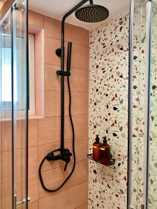 y baño con ducha y pared cubierta de mariposas. en Flat 126 en Alexandroupolis