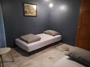 a small bed in a corner of a room at REQUELstore in Sungai Pelik