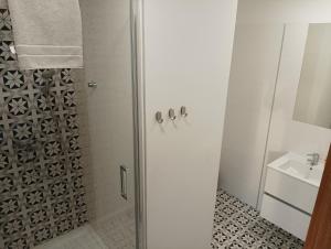 biała łazienka z prysznicem i umywalką w obiekcie Ośrodek Pomeranka w Gdańsku