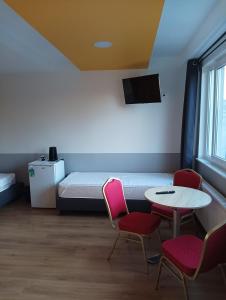 um quarto com uma cama, duas cadeiras e uma mesa em Ośrodek Pomeranka em Gdansk