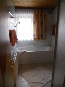 baño con bañera y ventana en Appartement beim Brunnen 12, en Sölden