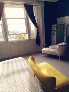 a living room with a yellow chair and a window at Upmarket 2 bedroom apartment with sea views in Torquay