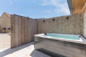 a bath tub sitting next to a stone wall at Cap d'Eau in Waasmunster