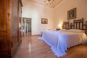 a bedroom with two beds and a chandelier at Casa Senatore in Capestrano