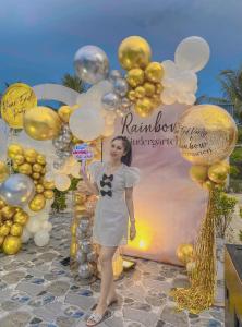 a woman standing in front of a bunch of balloons at The Dreamers Homestay in Hue +151 photos