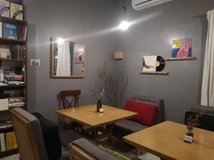 a room with two tables and chairs and a book shelf at REQUELstore in Sungai Pelik