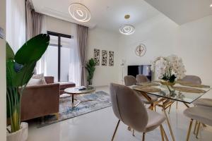 ein Wohnzimmer mit einem Esstisch und Stühlen in der Unterkunft Primestay - Damac Hills 2 Aster Villa 3 Bedroom in Dubai