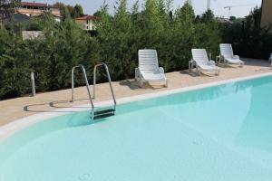 een zwembad met 2 ligstoelen en 2 ligstoelen bij Casa di Chiara in Peschiera del Garda