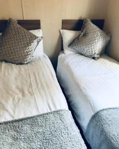 two beds with pillows sitting next to each other at Tummel valley holiday park in Tummel Bridge