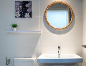 ein Badezimmer mit Waschbecken und Spiegel in der Unterkunft La Isleña House - Near the beach, Air-Con, Fast Wifi and SAT tv By Lanzarote Vacation Homes in Playa Blanca + 15 Fotos