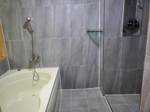 a bathroom with a shower and a bath tub at Sharp Hotel Jeonju in Jeonju