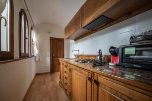 a kitchen with a microwave and a stove top oven at Casa Senatore in Capestrano