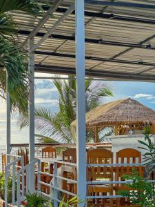 a patio with chairs and a table and a straw umbrella at Lanta A&J Klong khong Beach in Ko Lanta