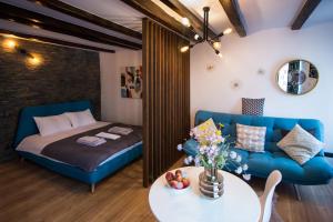 a living room with a blue couch and a table at Mystery Box Apartament incantator in Sibiu