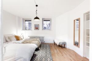 a white living room with a bed and a rug at Beautiful 3 Room apartment in Kreuzberg in Berlin