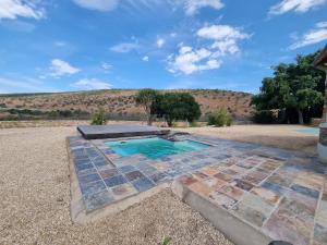 a swimming pool with a stone walkway around it at Zungah Lodge in Uitenhage