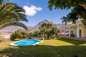 a house with a swimming pool in a yard at Modern Villa with heated pool and mountain views in Arona