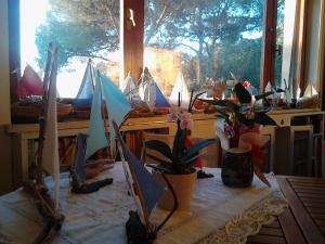 a room with a table with a bunch of sailboats in a window at La Casa di Ulisse B&B in Quercianella