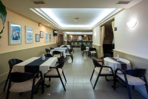 a restaurant with tables and chairs in a room at Motel Jardin in Oleiros