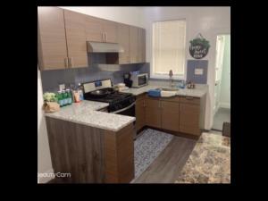 a kitchen with wooden cabinets and a stove top oven at Brand new bedroom with Tv next JHU in Baltimore