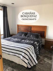 - une chambre avec un lit et une couverture noire et blanche dans l'établissement Cabaña bosquepaz, à Algarrobo
