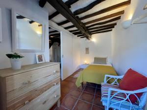 a bedroom with a bed and a dresser in a room at Casa O Refúgio in Lagoa