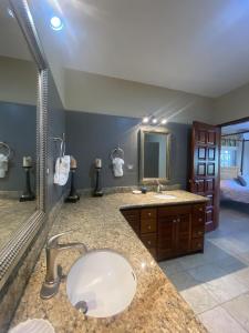 a bathroom with a sink and a large mirror at Los Porticos in Placencia