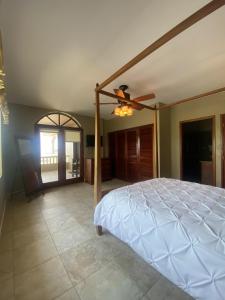 a bedroom with a bed and a ceiling fan at Los Porticos in Placencia Village