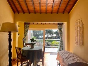 a dining room with a table and a door to a patio at Casa O Refúgio in Lagoa