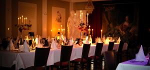a dining room with tables and chairs with candles at Seehotel Louise in Gransee