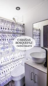 La salle de bains est pourvue de toilettes blanches et d'un lavabo. dans l'établissement Cabaña bosquepaz, à Algarrobo