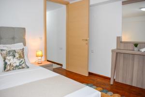 sypialnia z białym łóżkiem i lustrem w obiekcie La Maison Plakes 3 BDR Apt w mieście Skiatos