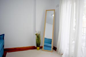 a mirror in a room with a vase next to a window at La Maison Plakes 3 BDR Apt in Skiathos
