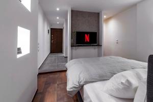 um quarto com uma cama e uma televisão na parede em Tsimiski Contemporary Studio 1 em Tessalônica