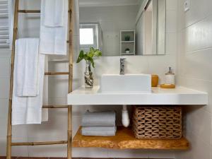 a bathroom with a sink and a mirror and towels at Casa O Refúgio in Lagoa +46 photos