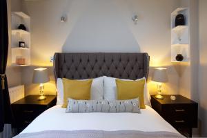 1 dormitorio con 1 cama grande y 2 mesitas de noche en Avari Apartments - Winchester Collection en Londres