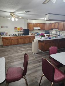 a large kitchen with wooden cabinets and tables and chairs at Family Budget Inn in Bethany