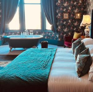 a bedroom with a large bed and a bath tub at The Gin Lounge Rooms in Ilkley