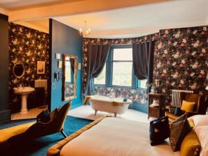 a bedroom with a bed and a tub and a sink at Mollys Boutique Hotel in Ilkley
