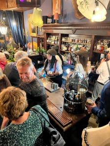 um grupo de pessoas em pé em torno de um bar em um restaurante em The Gin Lounge Rooms em Ilkley