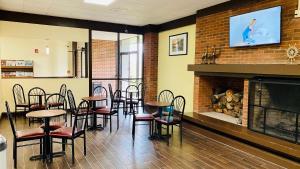 a dining room with tables and chairs and a fireplace at Days Inn by Wyndham Maysville Kentucky in Maysville