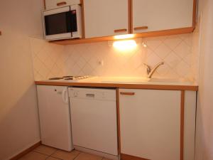 uma pequena cozinha com um lavatório e um micro-ondas em Appartement Peisey-Vallandry, 3 pièces, 6 personnes - FR-1-411-648 em Landry