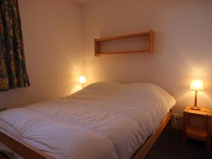 um quarto com uma cama branca e 2 candeeiros em Appartement Peisey-Vallandry, 3 pièces, 6 personnes - FR-1-411-648 em Landry