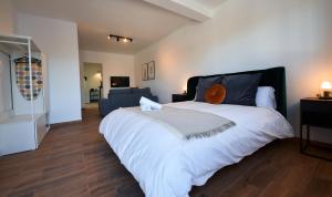 ein Schlafzimmer mit einem großen Bett und einem Sofa in der Unterkunft Apartamentos Sierra de Las Nieves in Ronda