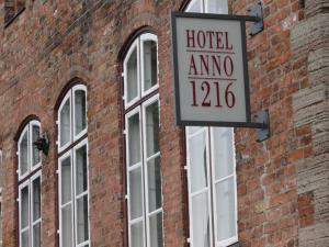 呂貝克的住宿－安諾1216酒店，砖砌建筑上的酒店阿莫诺标志